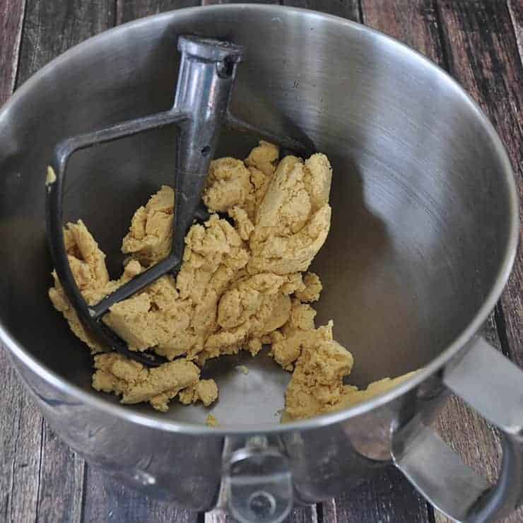 KitchenAid mixing bowl with corn tortilla dough inside of it.