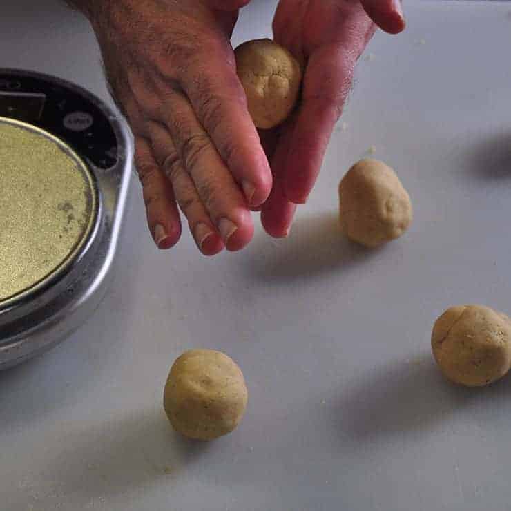 Four tortilla balls with one being rounded off in my hand for these homemade tortillas