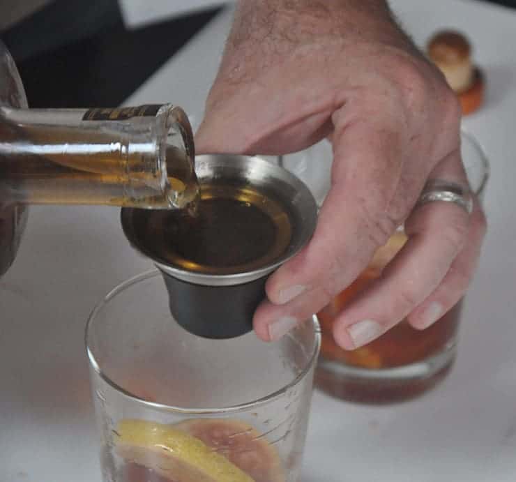 pouring whiskey for old fashioned