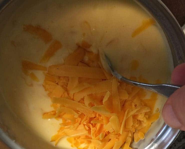 Mixing cheese into a mac and cheese bechemel.
