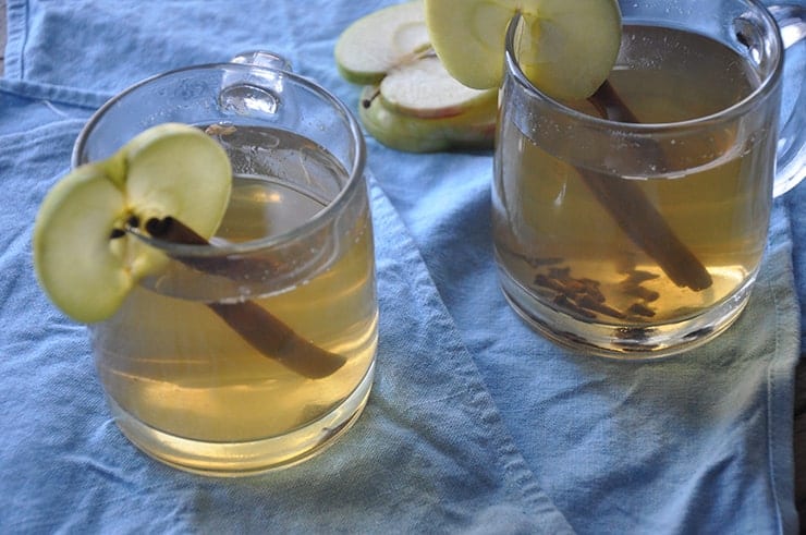 overhead shot of apple ginger hot toddy sitting on blue cloth