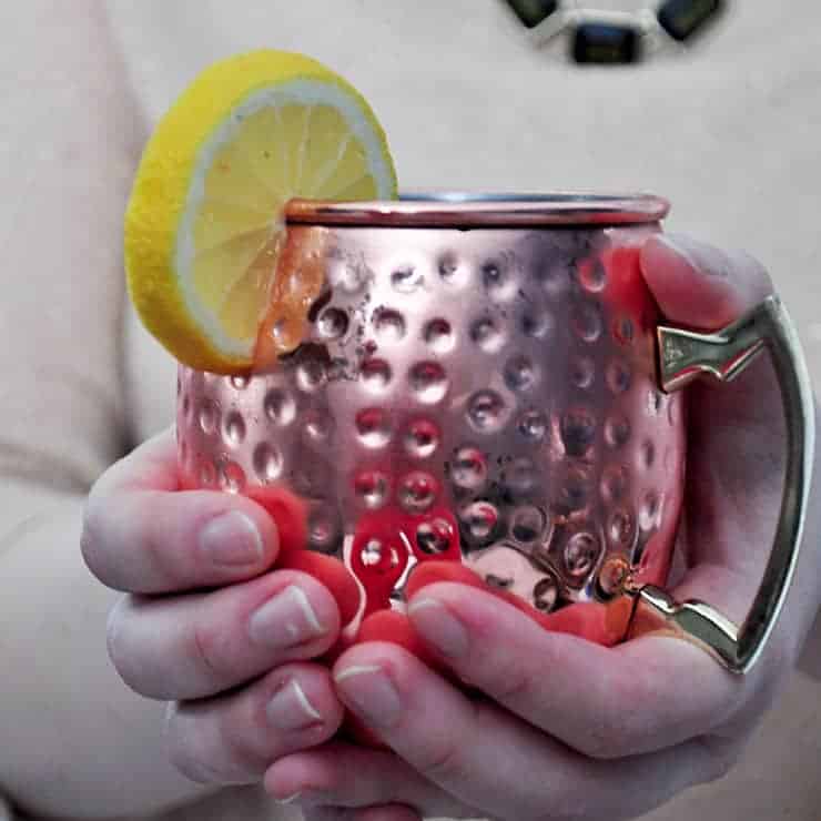 holding a finished Limoncello and Lavender Moscow Mule in hands