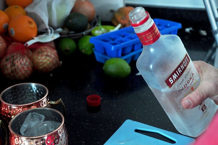 vodka being prepped to be poured into a copper mug.