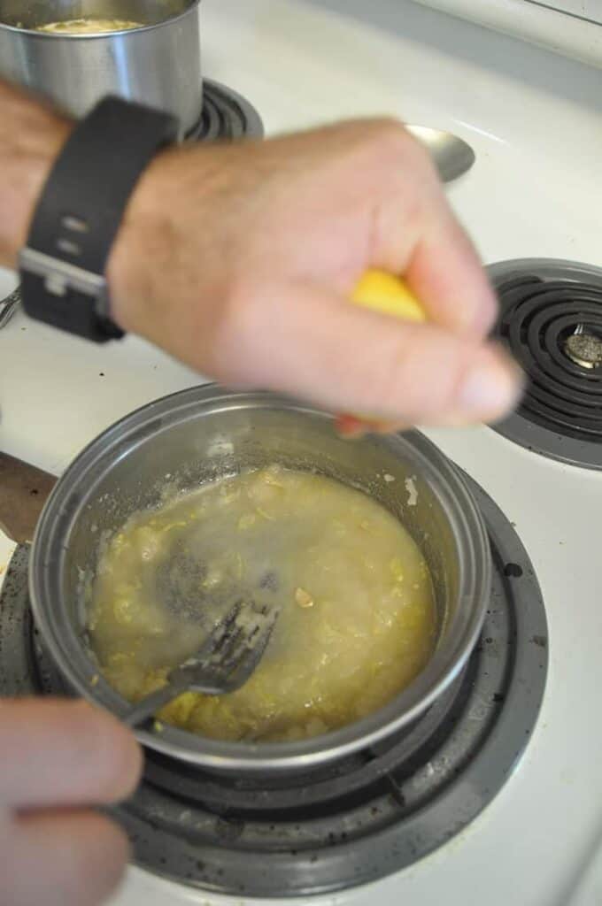 squeezing lemon into pan to make ice hot toddy topping.