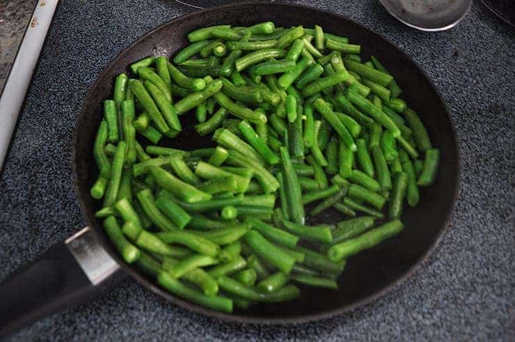 cooking some green beens in a pan