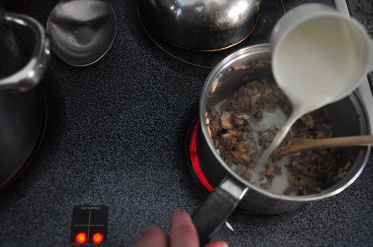 Pouring the cream into our mushroom roux.