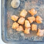 tater tot recipe feature image. Tater tots on a pan with a potato