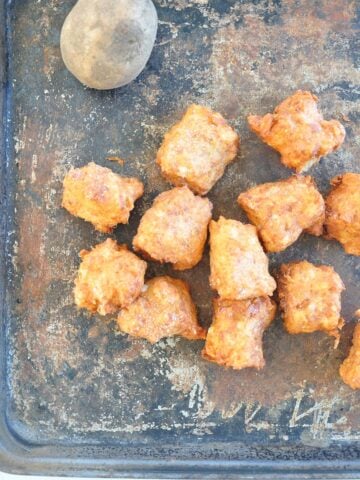 tater tot recipe feature image. Tater tots on a pan with a potato
