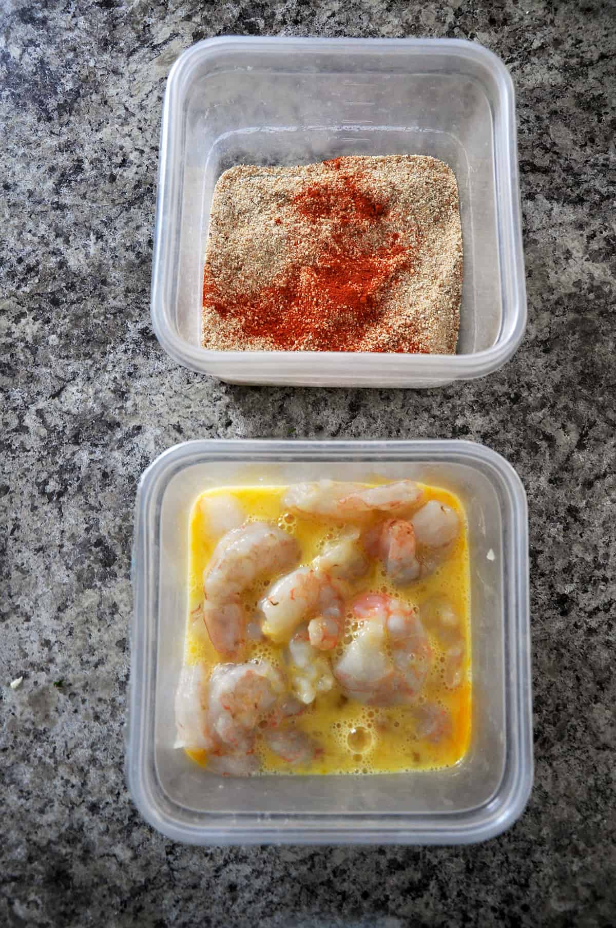 Shrimp in eggs mixture and the breadcrumb coating in a different dish.