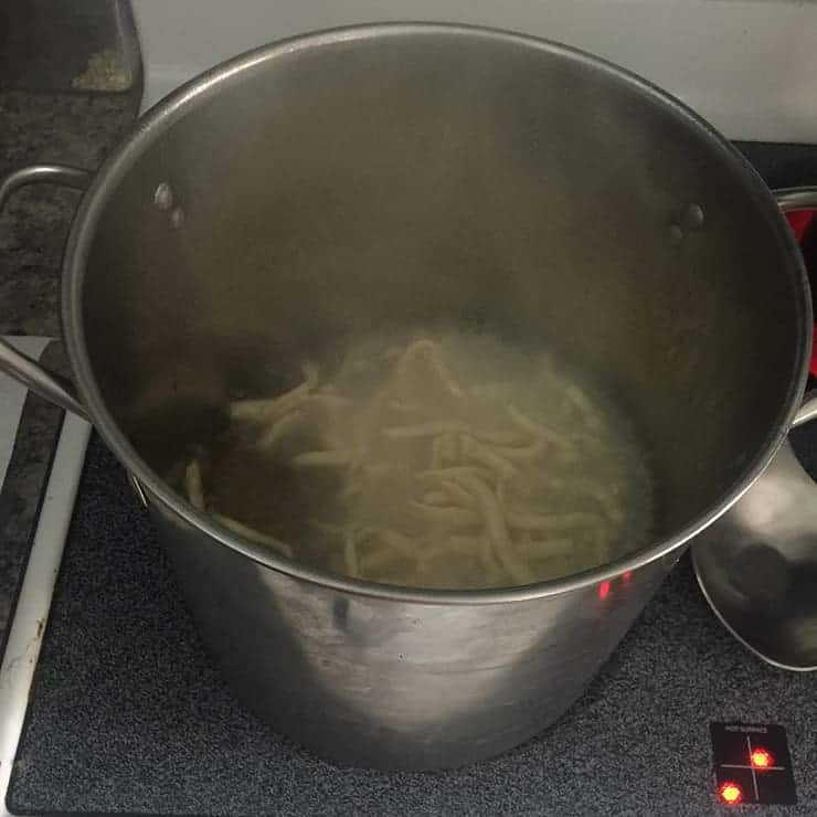 chow mein noodles deep fat frying in a big pot.