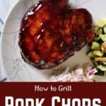"How To Grill Pork Chops Like a Boss" with an overhead shot of a porkchop on a white plate with a side of coleslaw and veggies.