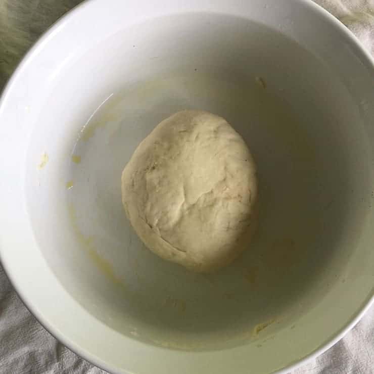 A ball of dough in a white bowl