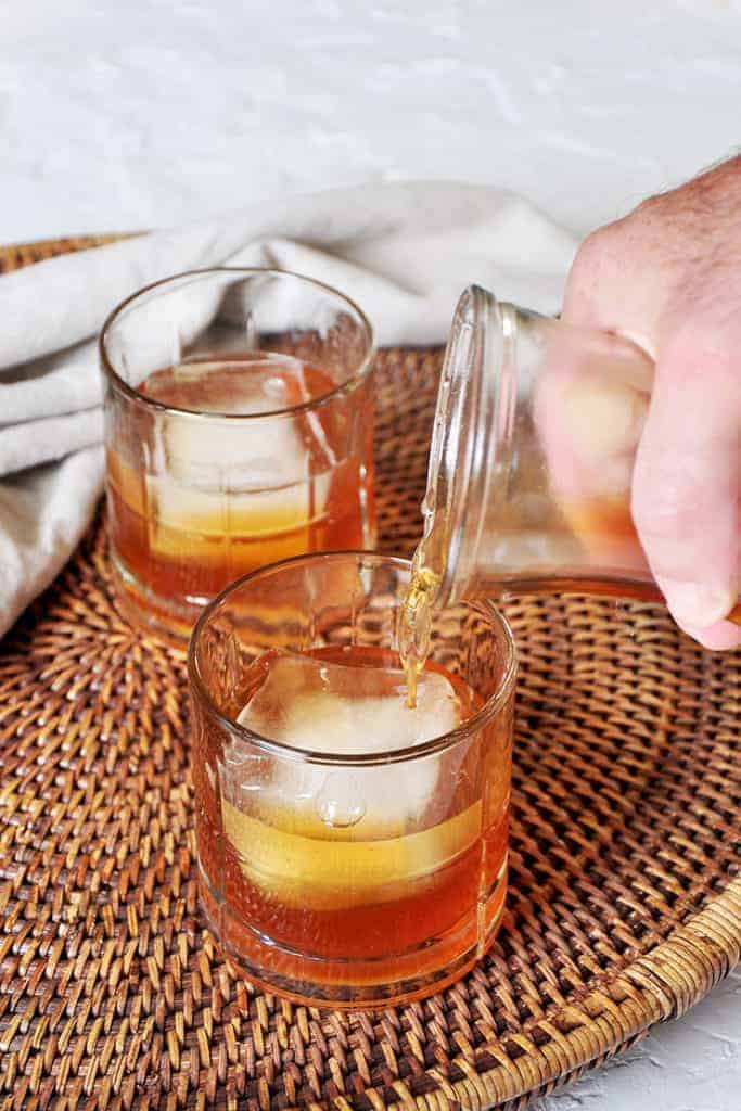 Pouring apple brandy into a glass from a carafe