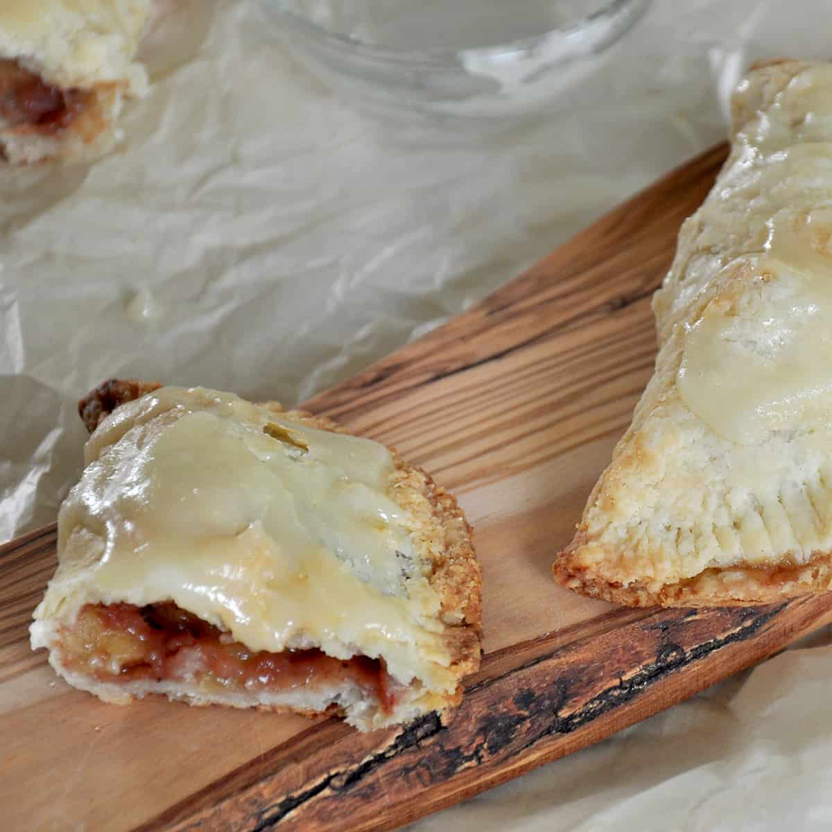 Half of an apple hand pie on a cutting board.