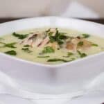 Creamy Chicken Soup in a white bowl that is in a white plate.