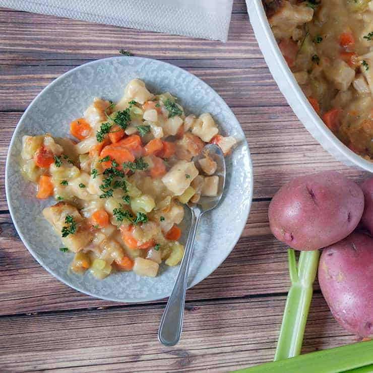 Knöpfle dumpling casserole on a picnic table with potatoes and celery in the background.