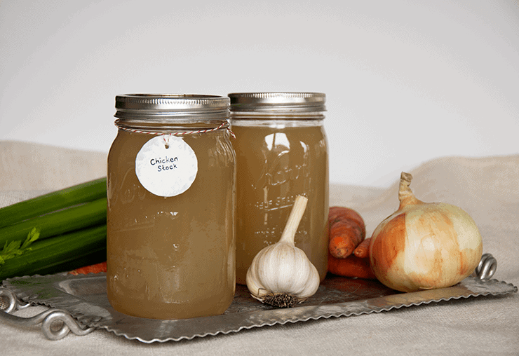 Two quarts of homemade chicken stock on a tin platter.