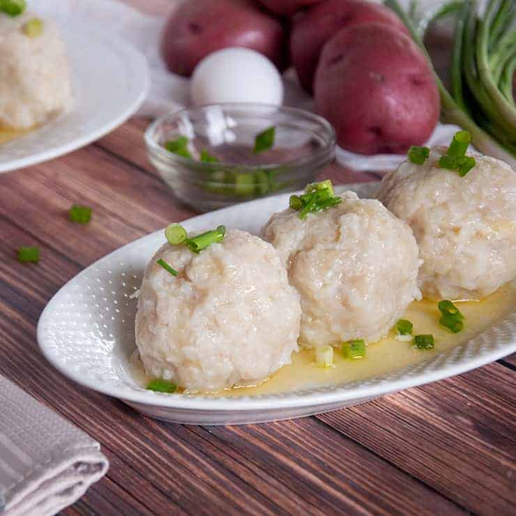 3 Klubb Dumplings with some of the ingredients in the background