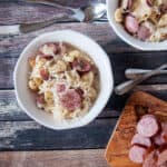 Knöpfle dumplings, sauerkraut and sausage in a bowl.