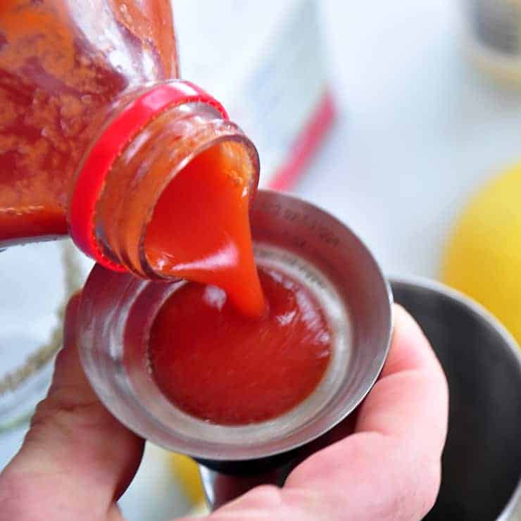 Pouring tomato juice into a jigger