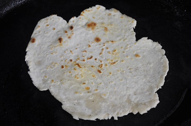 flour tortilla on a cast iron pan.