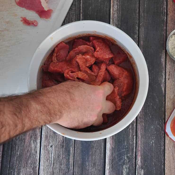 Mixing beef in bowl.