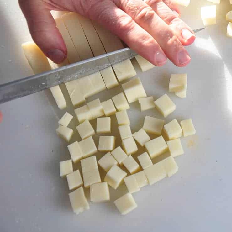 Cutting Mozzarella Cheese into cubes.