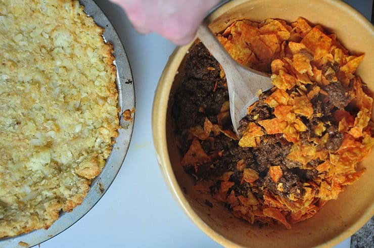 Mixing Dorito Beef and Cheese mixture before dumping in tater tot pie crust.