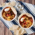 Overhead picture of two bowls of our easy taco soup on a blue and white napkin.