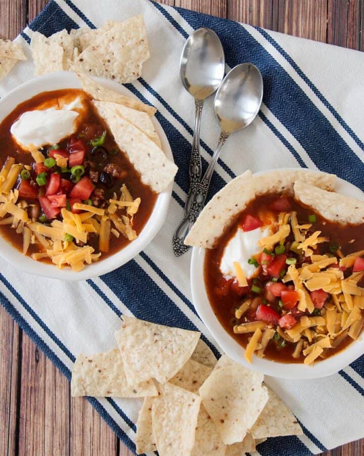 Overhead picture of two bowls of our easy taco soup on a blue and white napkin.
