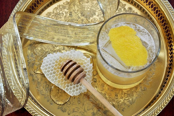 Overhead picture of a Gold Rush Cocktail on a gold platter with some honey comb