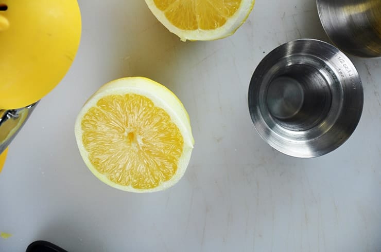 Cut Lemon in Half with a jigger to the side.