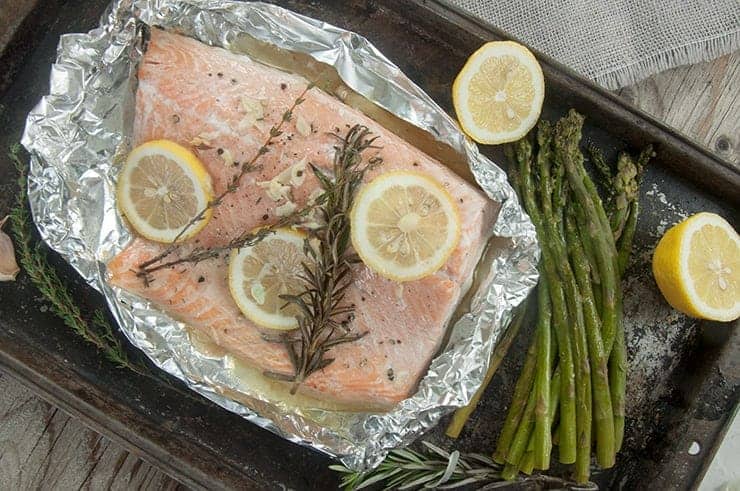 Diagonal view of tinfoil Grilled Salmon on a baking sheet.