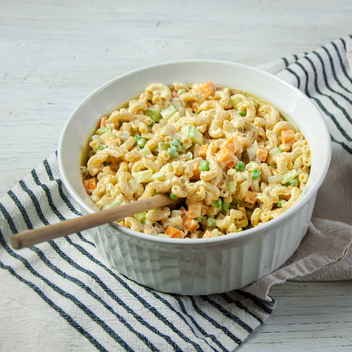 Rancharoni Macaroni in a large white dish and wooden spoon in it.