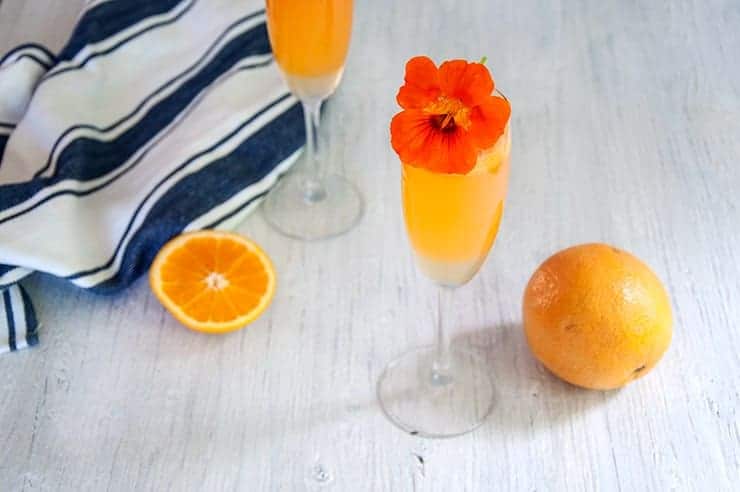 Prosecco Cocktail Spritz on a white table and garnished with a flower.