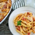 Pasta Al Forno serving on a white plate with a casserole dish off to the side.