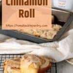 RumChata Glazed Cinnamon Rolls on a wire rack with a pan and bottle of RumChata in the background.
