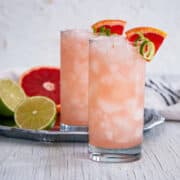 Two Paloma Cocktail recipes made - one on a white table and the other on a silver platter.