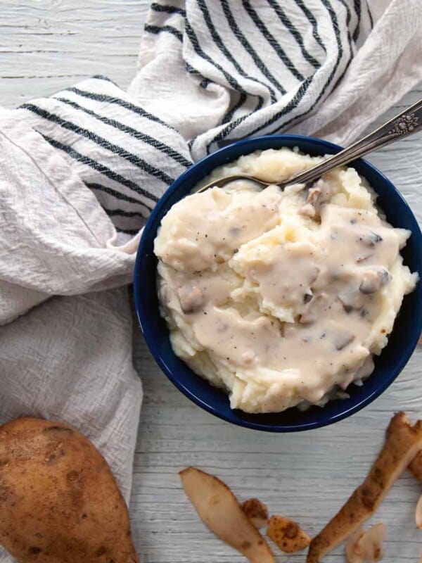 Make Ahead Sous Vide Mashed Potato in a blue bowl and mushroom gravy.