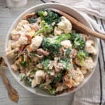 Extra Baconey Amish Broccoli Salad Recipe in a white bowl with a wooden spoon!