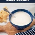 Easy Homemade Sour Cream with a bowl of sour cream on a cutting board.