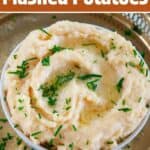 "Easy, Creamy, & Cheesy Mashed Potatoes" with a bowl of the potatoes on a gold platter and chopped chives sprinkled on top.