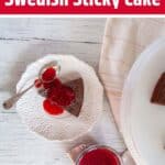 Kladdkaka Swedish Sticky Cake on a white cake with a dish of raspberry topping on the side.