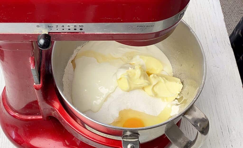 Creamy ingredients, butter, egg, flour, and sugar in KitchenAid mixing bowl.