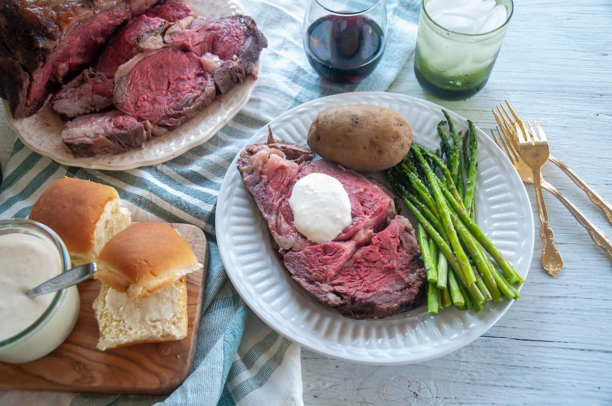 Full Sous Vide Prime Rib layout with a plate of meat, asparagus, potato, and horsey sauce.