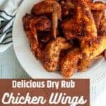 Delicious Dry Rub Chicken Wings with a plate of wings on a white napkin.