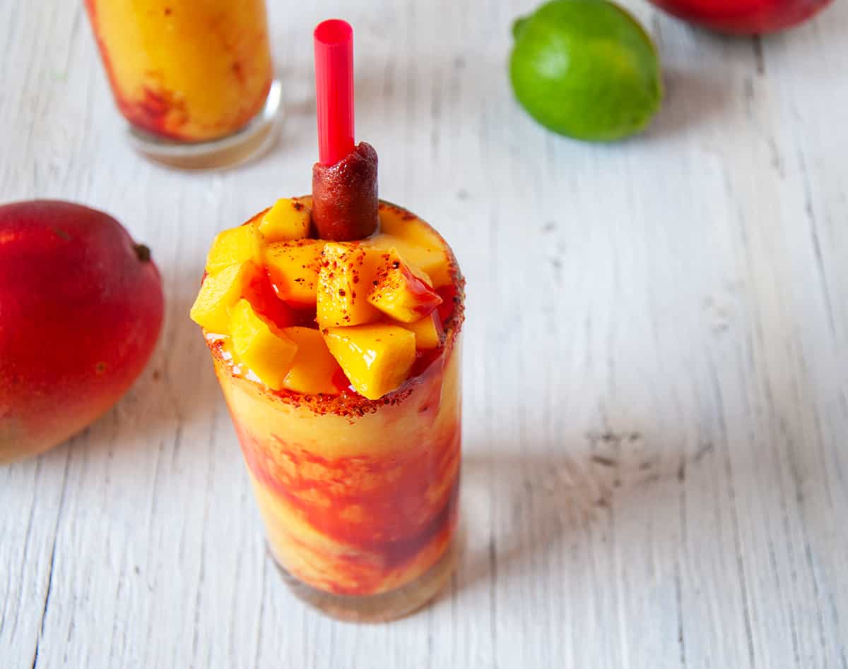 Mangonada with fresh mango on top, chamoy sauce, and Tajin.