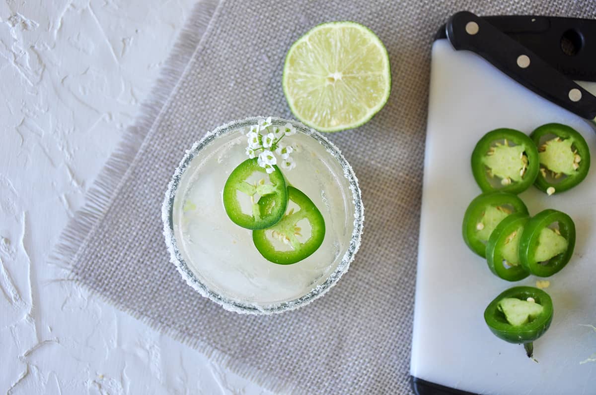 Spicy Margarita with a salted rim and jalapenos off to the side.