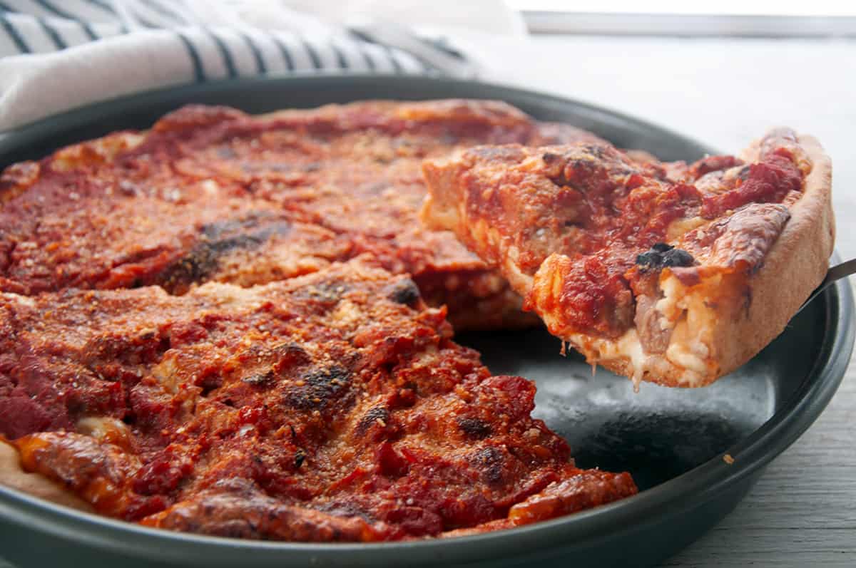 Slice of Chicago Deep Dish on a white plate.