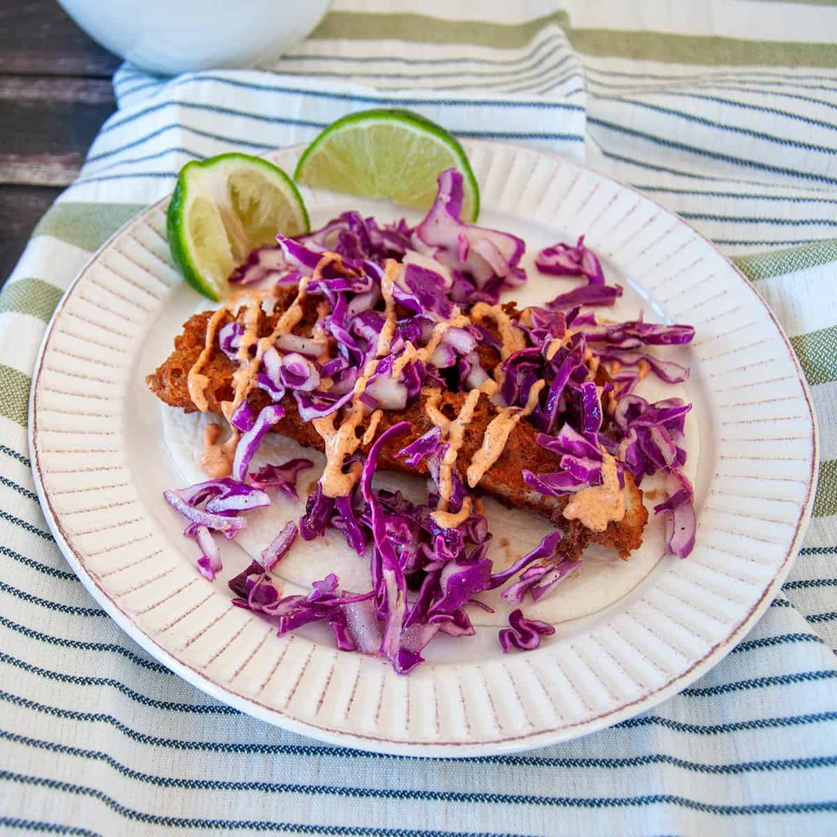 Beer Battered Fish Taco with cabbage and baja sauce.